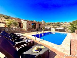 eine Villa mit einem Pool und einer Terrasse mit Stühlen in der Unterkunft VH CostaBlanca - CALIMA in Benissa