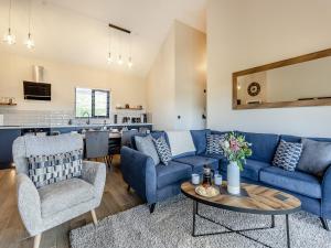 a living room with blue couches and a table at The Lara - Uk45019 in Mochdre