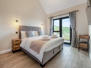 a bedroom with a large bed and a large window at The Lara - Uk45019 in Mochdre