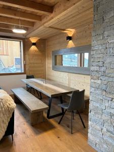 een eetkamer met een tafel en een stenen muur bij Chalet Chablis in Les Deux Alpes