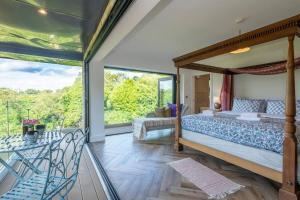 um quarto com uma cama de dossel e uma varanda em Rural retreat by the river em Norwich