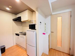 een keuken met een koelkast en een fornuis bij Jun KBK- 606 in Tokyo
