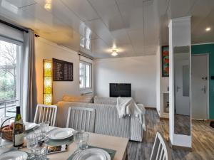 a living room with a couch and a table with chairs at Cosy apartment on Strasbourg Tramway line and Canal - Appartement confortable sur ligne tram Strasbourg et Canal in Bischheim