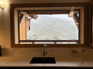 een raam boven een wastafel in een badkamer met uitzicht bij Chalet Chablis in Les Deux Alpes