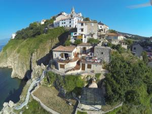 a house on a cliff next to the ocean at Old Town Vrbnik Villas in Vrbnik