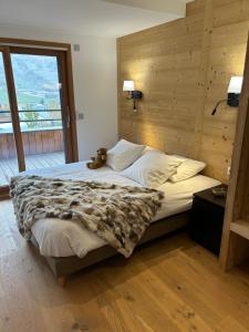 een slaapkamer met een bed met een teddybeer erop bij Chalet Chablis in Les Deux Alpes