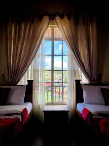 - une chambre avec 2 lits et une grande fenêtre dans l'établissement Shevyhaws, à Nuwara Eliya