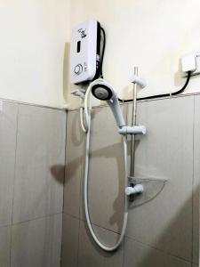 um chuveiro na casa de banho com um telefone na parede em Shevyhaws em Nuwara Eliya