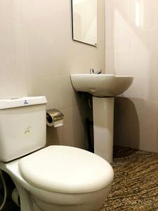 La salle de bains est pourvue de toilettes blanches et d'un lavabo. dans l'établissement Shevyhaws, à Nuwara Eliya