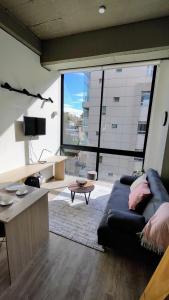 a living room with a couch and a large window at Elegante Loft en Chapinero! 401 in Bogotá