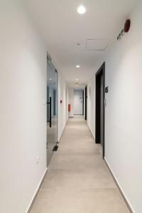 um corredor num edifício de escritórios com paredes brancas e um longo corredor em Athens Theatrou Apartments em Atenas