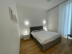 米蘭的住宿－IMHOME - Dante，一间卧室配有一张带2个床头柜和2盏灯的床。