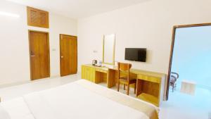 a hotel room with a desk and a television at Crown Palace Residence in Dhaka