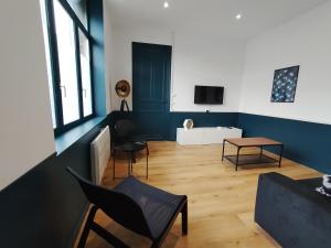 ein Wohnzimmer mit blauen Wänden sowie einem Tisch und Stühlen in der Unterkunft Résidence Beaudelot in Saint-Saulve