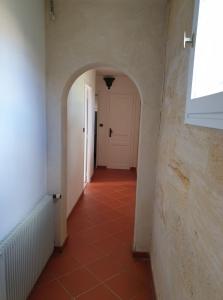 a hallway with a white door and a red tile floor at Halte au beau Millet in Coutras