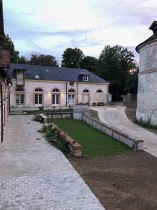 ein großes weißes Haus mit Rasen davor in der Unterkunft Chateau de Tosny 