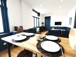 ein Wohnzimmer mit einem Tisch mit Brille und einem Sofa in der Unterkunft Résidence Beaudelot in Saint-Saulve