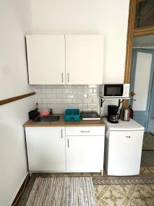 a small kitchen with white cabinets and a sink at Barcelona Central Apartments in Barcelona