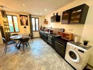 a kitchen with a washing machine and a table with chairs at Appart cosy au calme, dans le centre de Bandol in Bandol +2 photos
