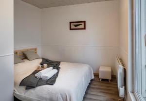 een slaapkamer met een bed met handdoeken erop bij Cosy flat in Strasbourg with an access to tramway - Appartement confortable sur ligne de tram de Strasbourg in Bischheim
