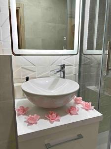 - un lavabo avec des fleurs roses sur un comptoir dans l'établissement Apartment J&S, à Dubrovnik
