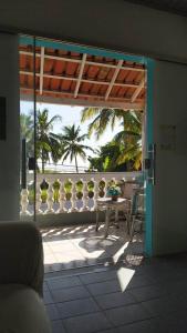 a patio with a table and a view of the ocean at Pousada Tropicália Tranquilidade a Beira Mar in Santa Cruz Cabrália