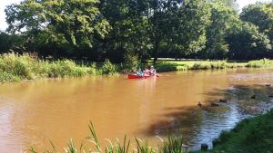 dwoje ludzi w łodzi na rzece z kaczkami w obiekcie logies 'Raapbreuk' w mieście Herentals