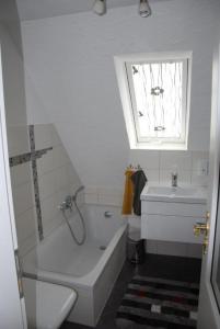 a bathroom with a tub and a toilet and a sink at Ferienwohnung Neue Schmiede in Helmershausen
