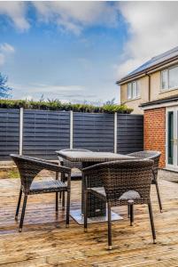 a patio with a table and chairs on a deck at 3 Bed House, Perfect for Business and Contractors in Nottinghamshire in Plumtree