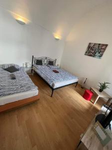 sypialnia z 2 łóżkami i drewnianą podłogą w obiekcie Budget Studio for Couples in the Heart of City w Koszycach