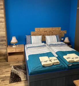 a blue bedroom with a bed with towels on it at Уютен апартамент Мечта in Vratsa