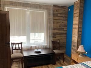een slaapkamer met een tafel en 2 stoelen en een raam bij Уютен апартамент Мечта in Vratsa