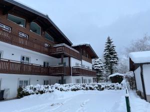 un edificio de apartamentos con nieve en el suelo en Haus Breitenfellner by AlpenTravel en Bad Hofgastein