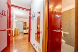 einen Flur mit einer roten Tür und einem Badezimmer in der Unterkunft Residenza Juvarra - Exclusive Flat in Turin