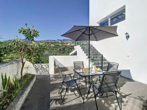 a table and chairs with an umbrella on a patio at Casa Santa Rita by Atlantic Holiday in Funchal