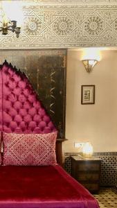 1 dormitorio con 1 cama con cabecero rojo en Riad Ibn Battouta & Spa en Fez