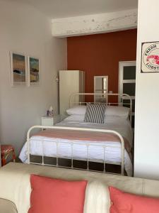 - une chambre avec un grand lit aux murs rouges dans l'établissement Appartement au Port, à Dinan