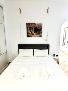 una camera da letto con un letto bianco con due asciugamani di Cozy Studio by the sea in Paleo Faliro ad Atene