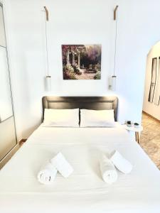 um quarto com uma cama branca com duas toalhas em Cozy Studio by the sea in Paleo Faliro em Atenas