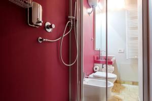 bagno rosso con servizi igienici e doccia di B&B Fermata 106 da Carolina a Siculiana Marina