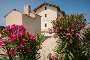 a building with pink flowers in front of a building at B&B Fermata 106 da Carolina in Siculiana Marina