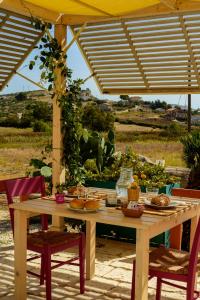 a table with food on it under an umbrella at B&B Fermata 106 da Carolina in Siculiana Marina