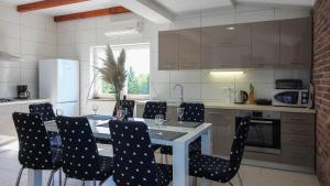 une cuisine avec une table et des chaises noires dans l'établissement Large Villa with amazing private pool near the beach and town, à Pula