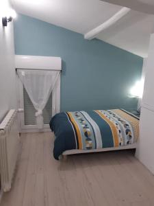 - une chambre avec un lit dans une pièce bleue dans l'établissement Charmante maison rénovée, proche lac et centre-ville, à LʼIsle-Jourdain