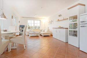 eine Küche und ein Wohnzimmer mit weißen Schränken in der Unterkunft Residenz Kurparkhöhe Appartement Meerzeit in Scharbeutz