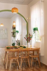 comedor con mesa de madera y sillas en Entire First Floor - Nguyên Tầng Trệt- Nhà Mơ Homestay Bến Tre, en Ben Tre
