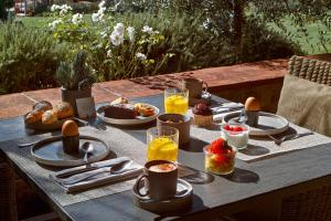 - une table avec des aliments et des boissons pour le petit-déjeuner dans l'établissement Locanda Le Piazze, à Castellina in Chianti