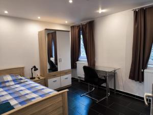 a bedroom with a bed and a desk and a table at Pension Isabel I in Bremen