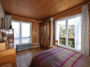 a bedroom with a bed and two large windows at Appartement Megève, 4 pièces, 8 personnes - FR-1-453-14 in Megève