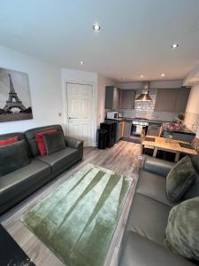 a living room with a couch and a table at Pinfold Court Apartments in Knowsley